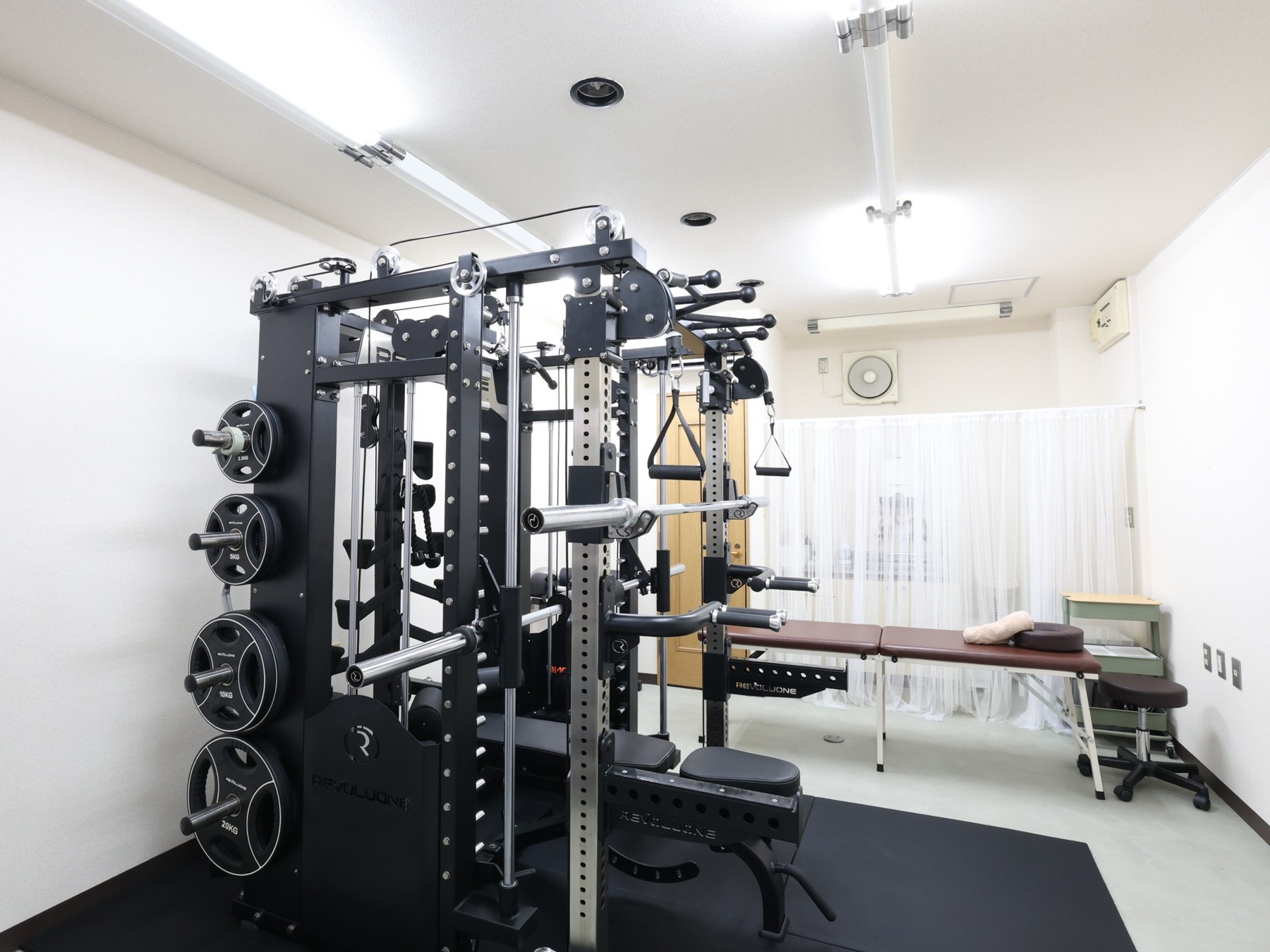 トトノウ×カワルのトレーニング機器と施術ベッドのある店内